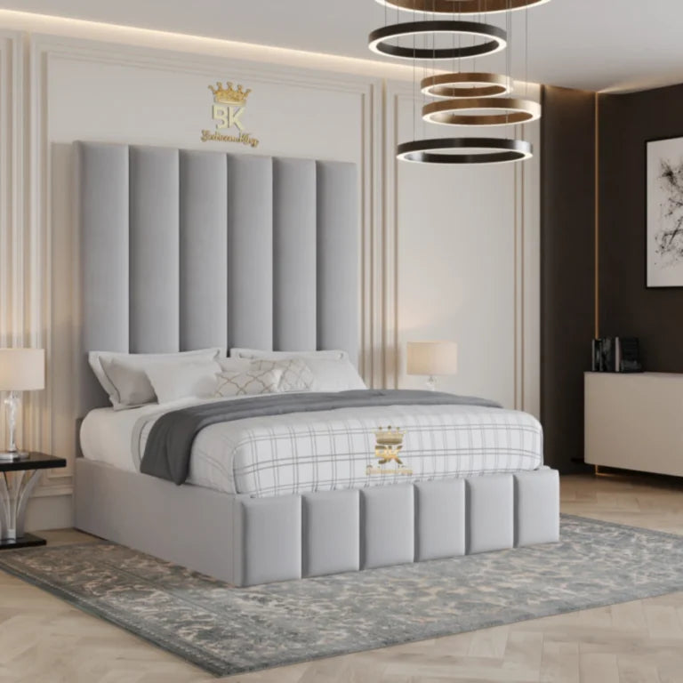 Gray upholstered bed in a stylish bedroom with decorative headboard and lighting.