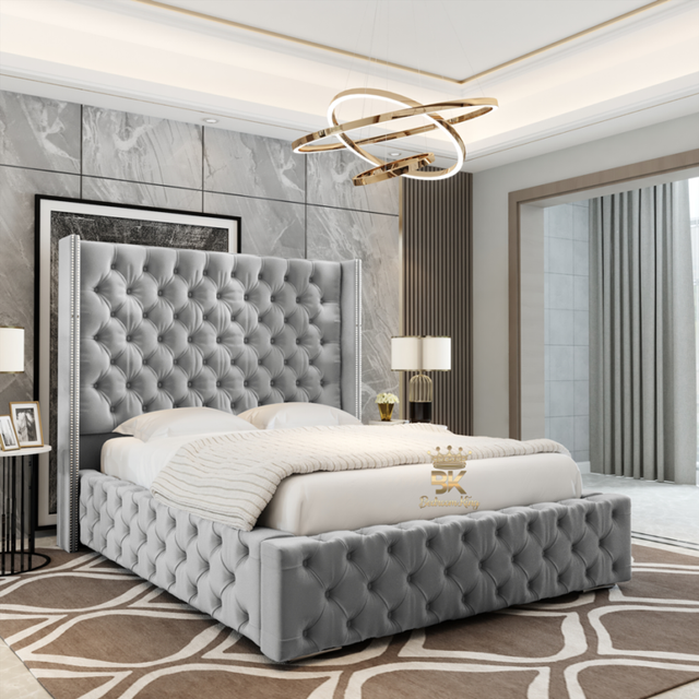Gray tufted bed in a stylish bedroom with marble walls and modern decor.