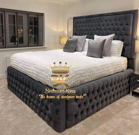Luxury bedroom with a tufted black bed and white bedding, featuring the Bedroom King logo.